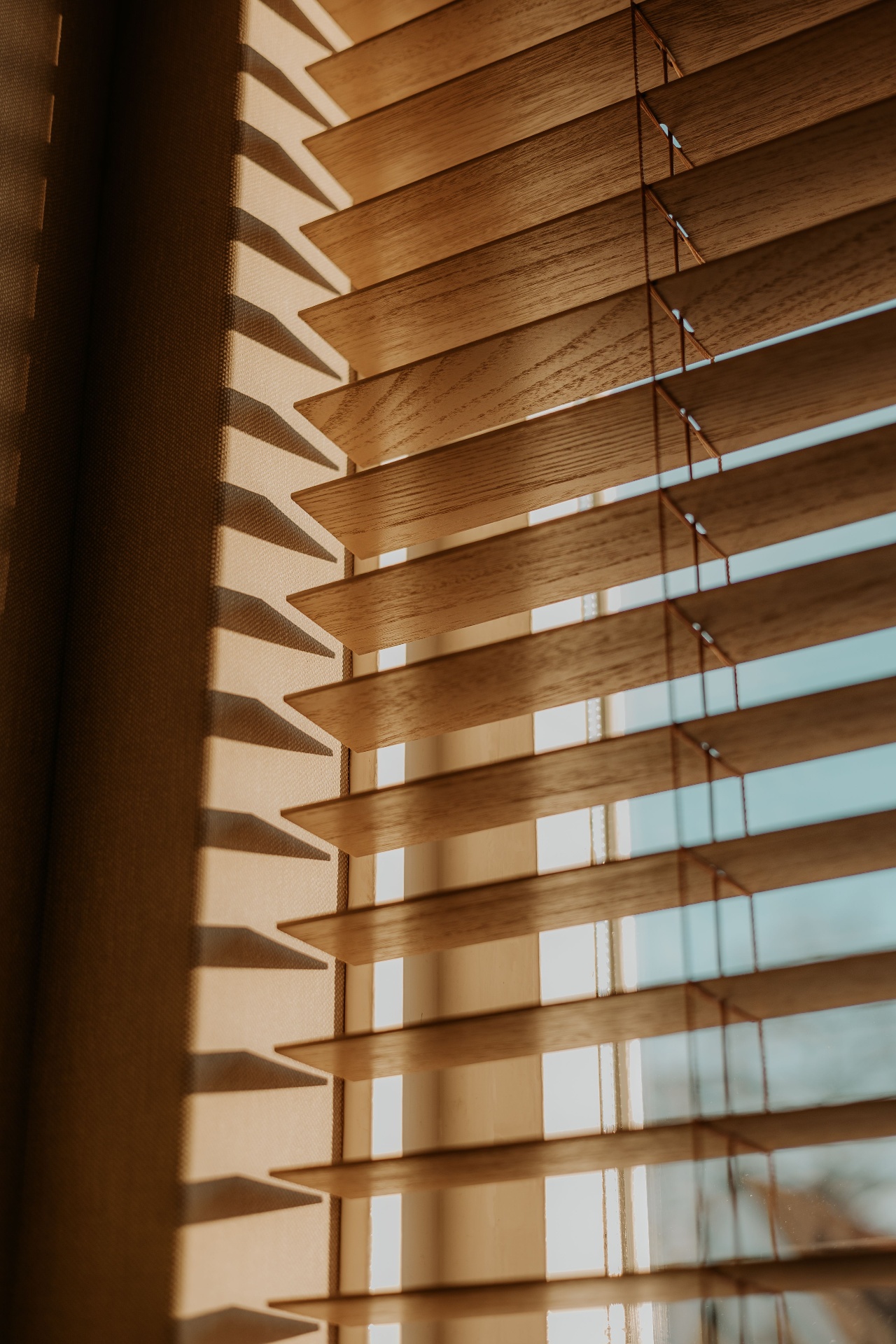Houten jaloezieën met vitrage, warm licht in woonkamer